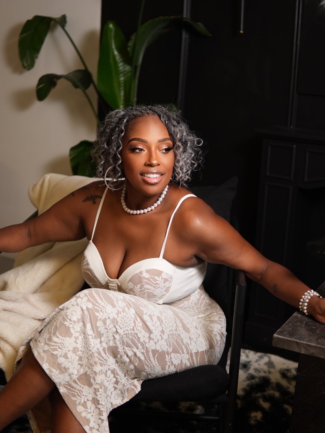 B. Johnson-Gray in a white lace dress in a softly lit interior